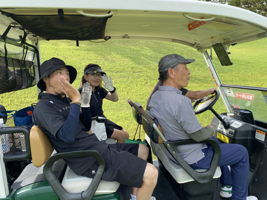 ゴルフカートに乗りラウンドを移動する男女