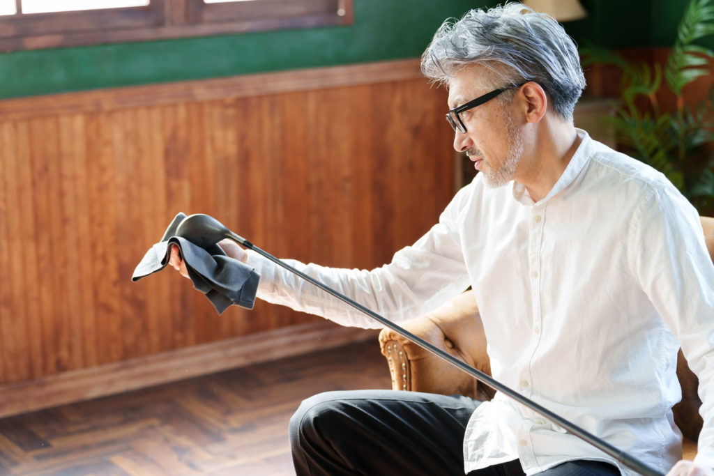 ゴルフクラブを掃除するミドル男性